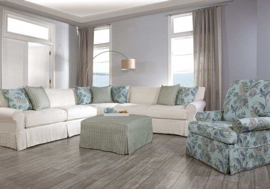 Cozy living room with a light sectional sofa and a soft ottoman.